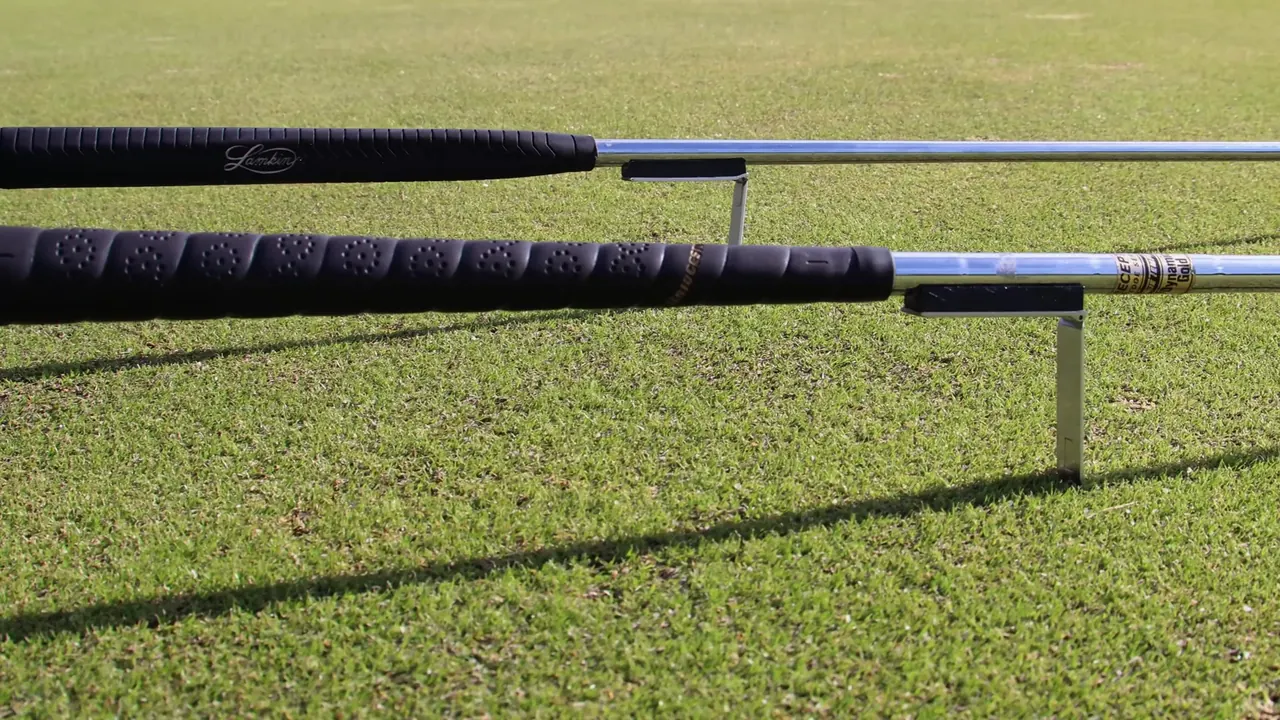 Two golf clubs held off the grass by Grip Keeper kickstands